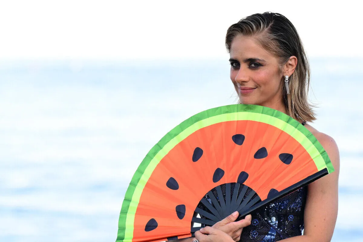Greta Scarano mostra un ventaglio con anguria al photocall del festival di Venezia