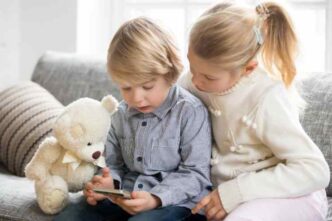Kids Boy Girl Using Smartphone Together Sitting Sofa 1